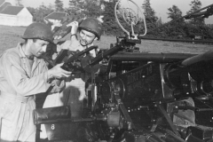 sandy and johns prepare an ack ack gun for action.