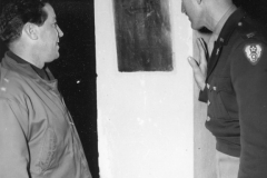 general and chaplain look at plaque in chapel