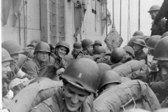 crowded landing craft are lowered away. 32 air service group. 9th tac.