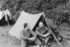 sandy and john talk in front of their pup tents. saint Marie. July 194